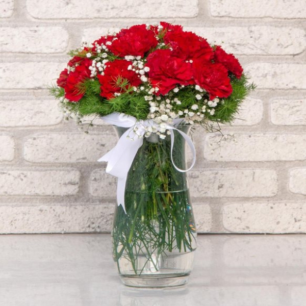 red carnation arrangement in glass vault